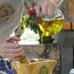 Vertiendo aceite de oliva puro en cocina rústica, elaborado de forma tradicional desde nuestro olivar