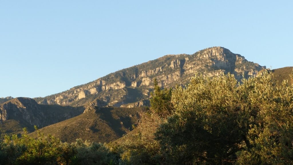 Montaña recibiendo la primera luz del día, reflejando el llamado a despertar y volver al camino de la luz.