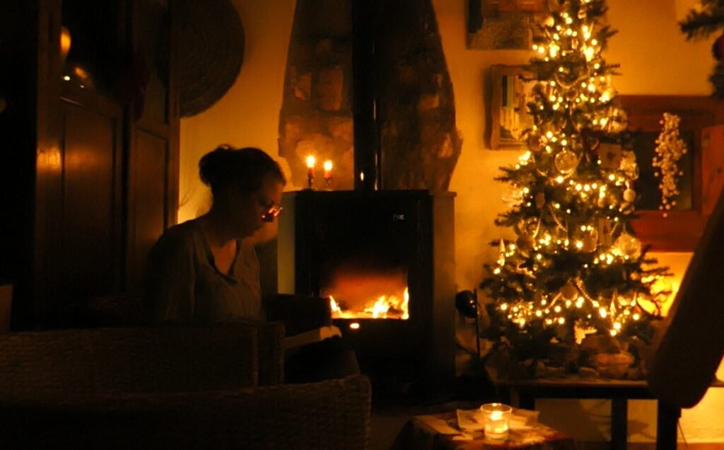 Cozy living room with a glowing Christmas tree and fireplace, capturing a moment of peace, arrival, and quiet joy during Christmas night.